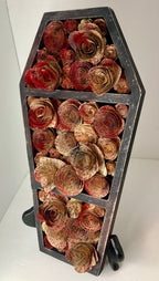 Coffin with blood splattered book roses