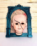 Broken doll art with decorative frame