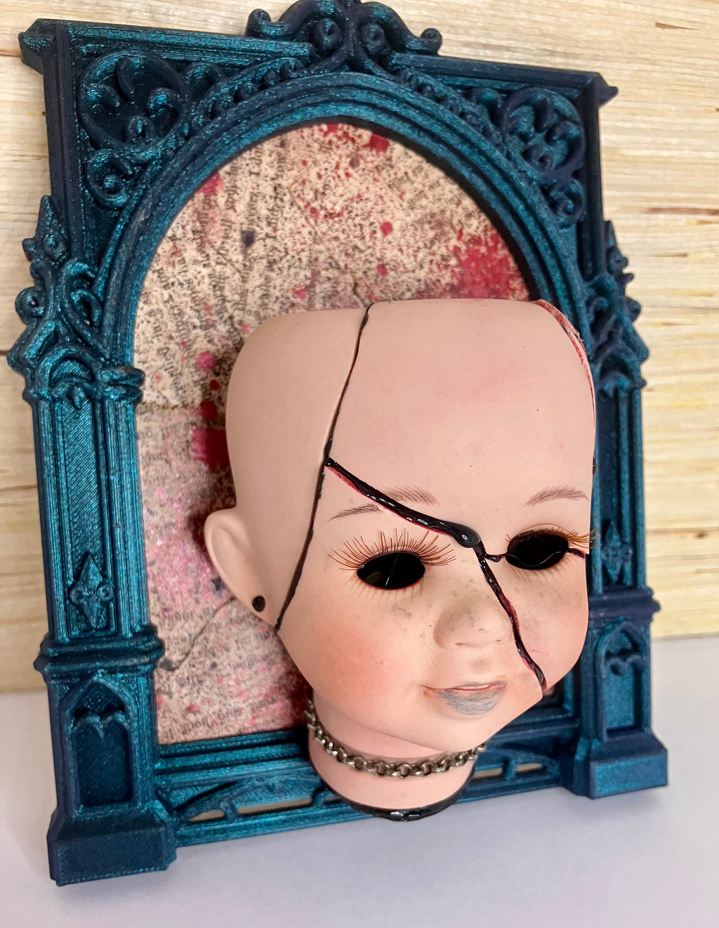 Broken doll art with decorative frame