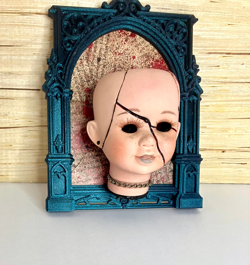 Broken doll art with decorative frame